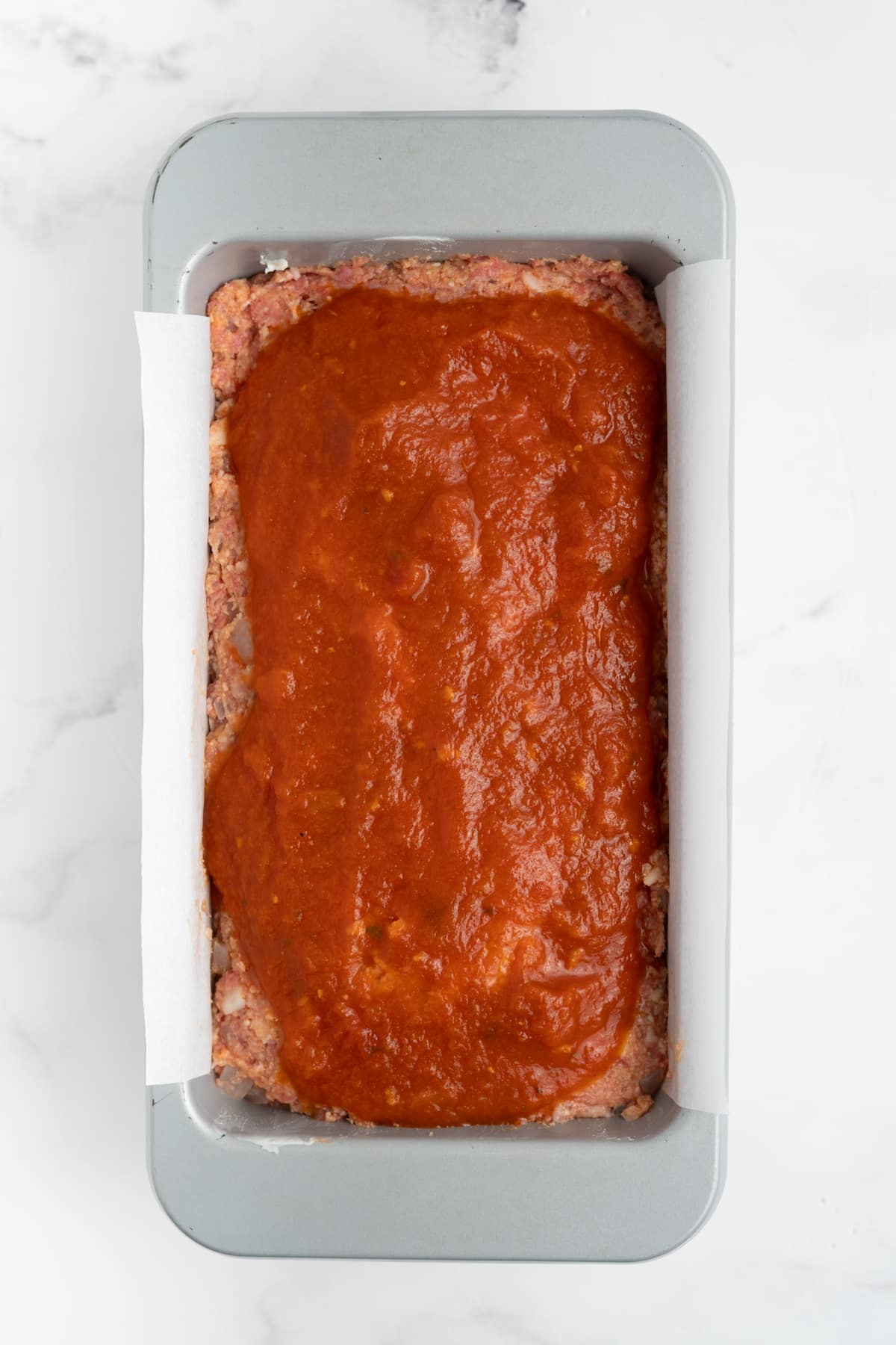 The marinara sauce poured over the meatloaf.