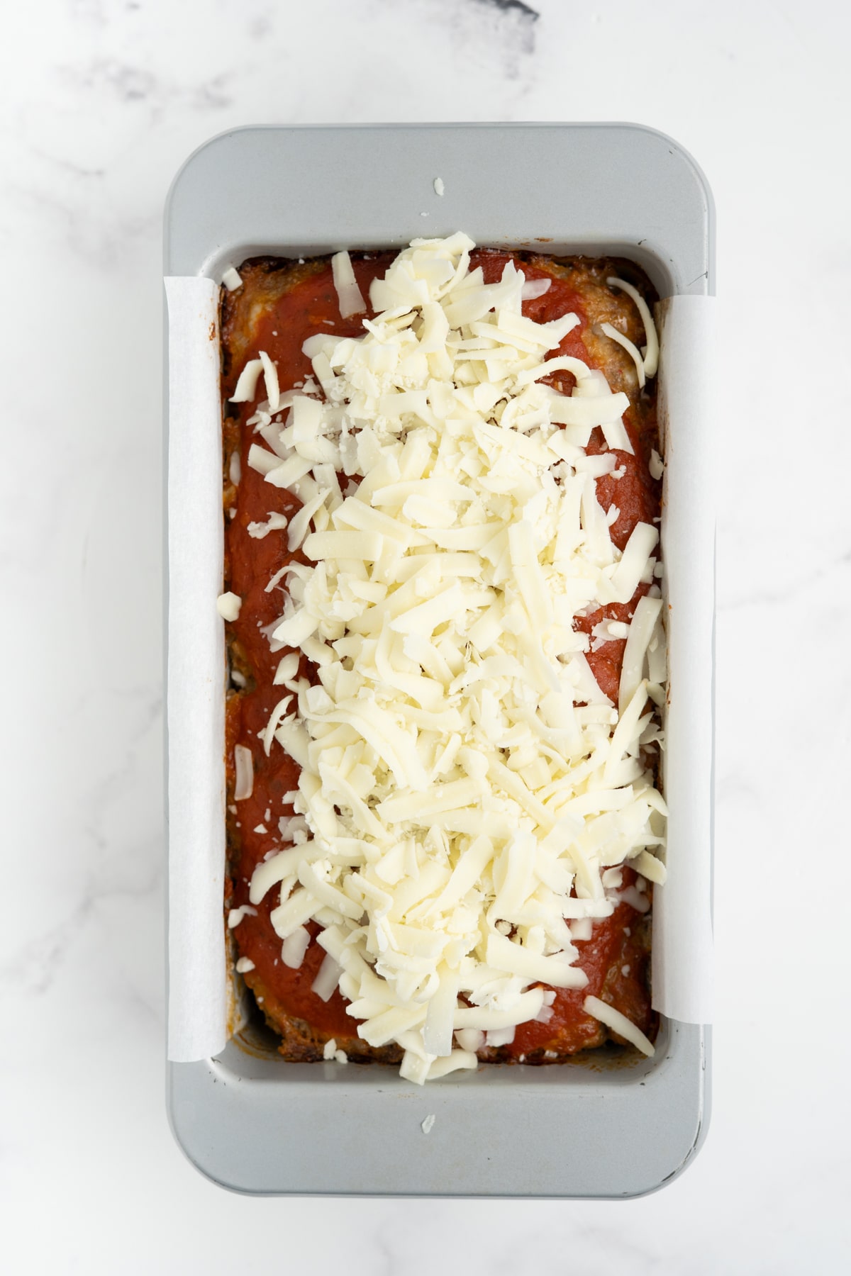 Cheese added on top of the Italian meatloaf.