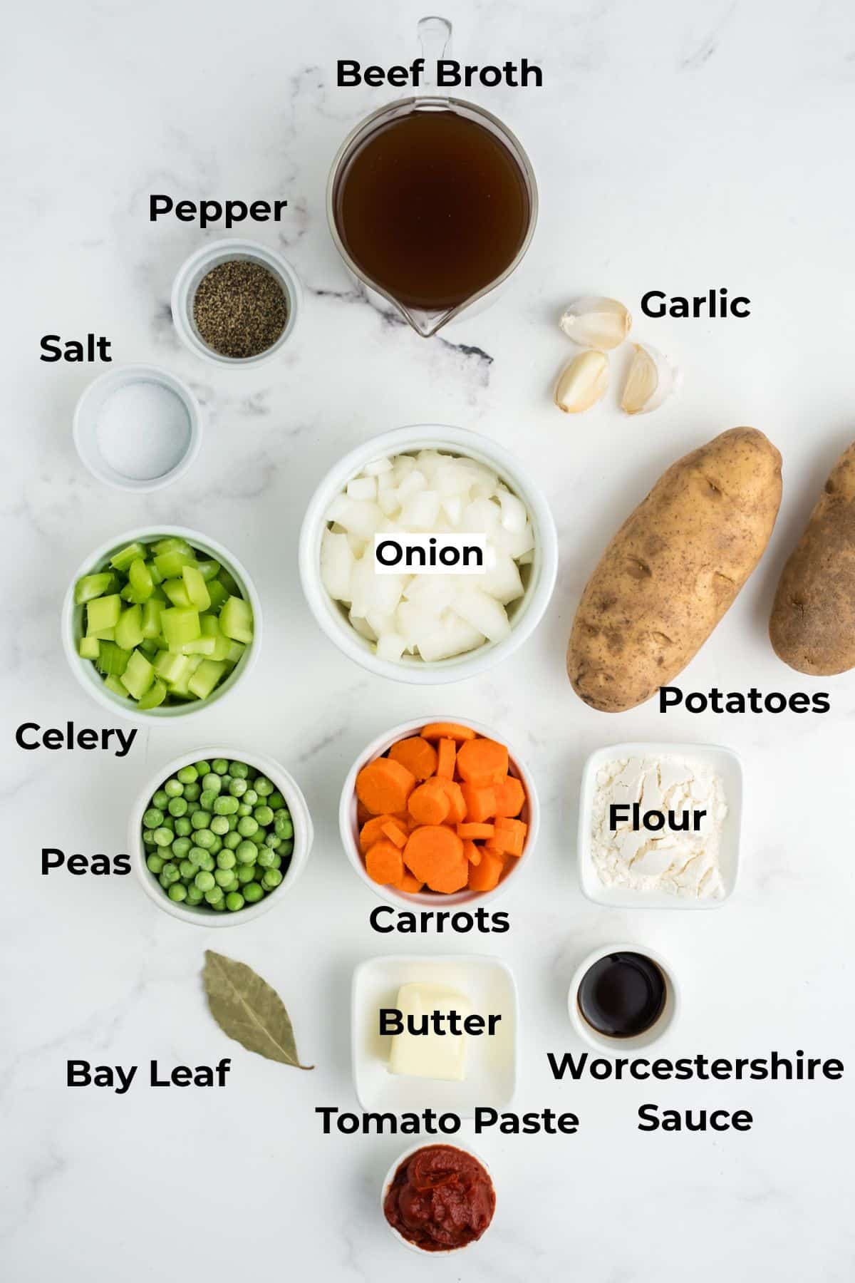 Ingredients to make this meatball stew in bowls on a table.