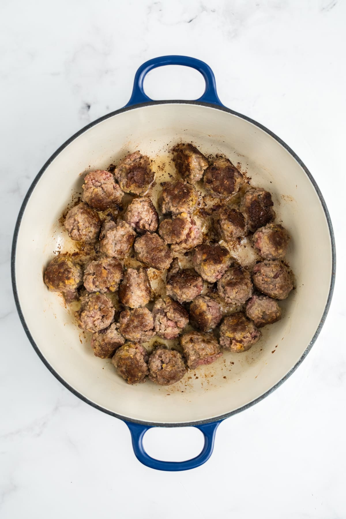 Meatballs cooking in a pot.