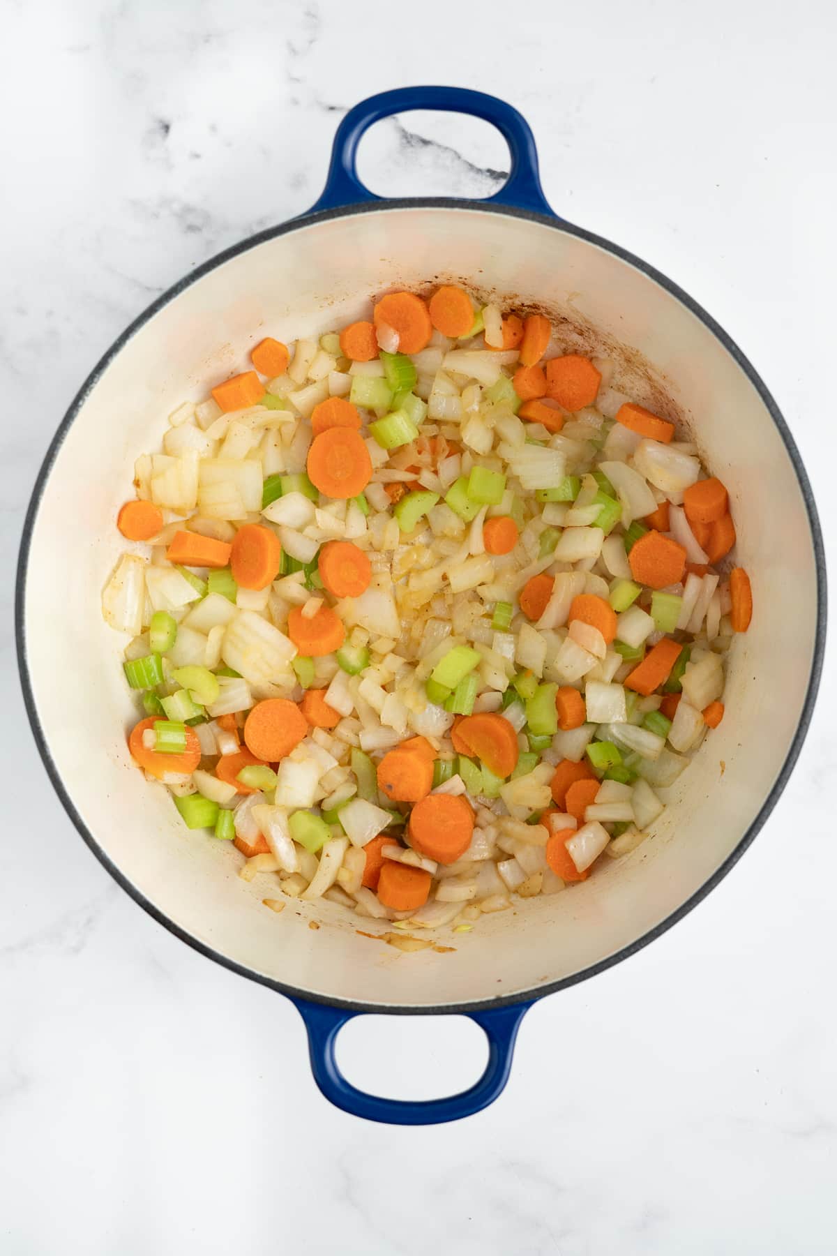 Onions, carrots, and celery in a pot.