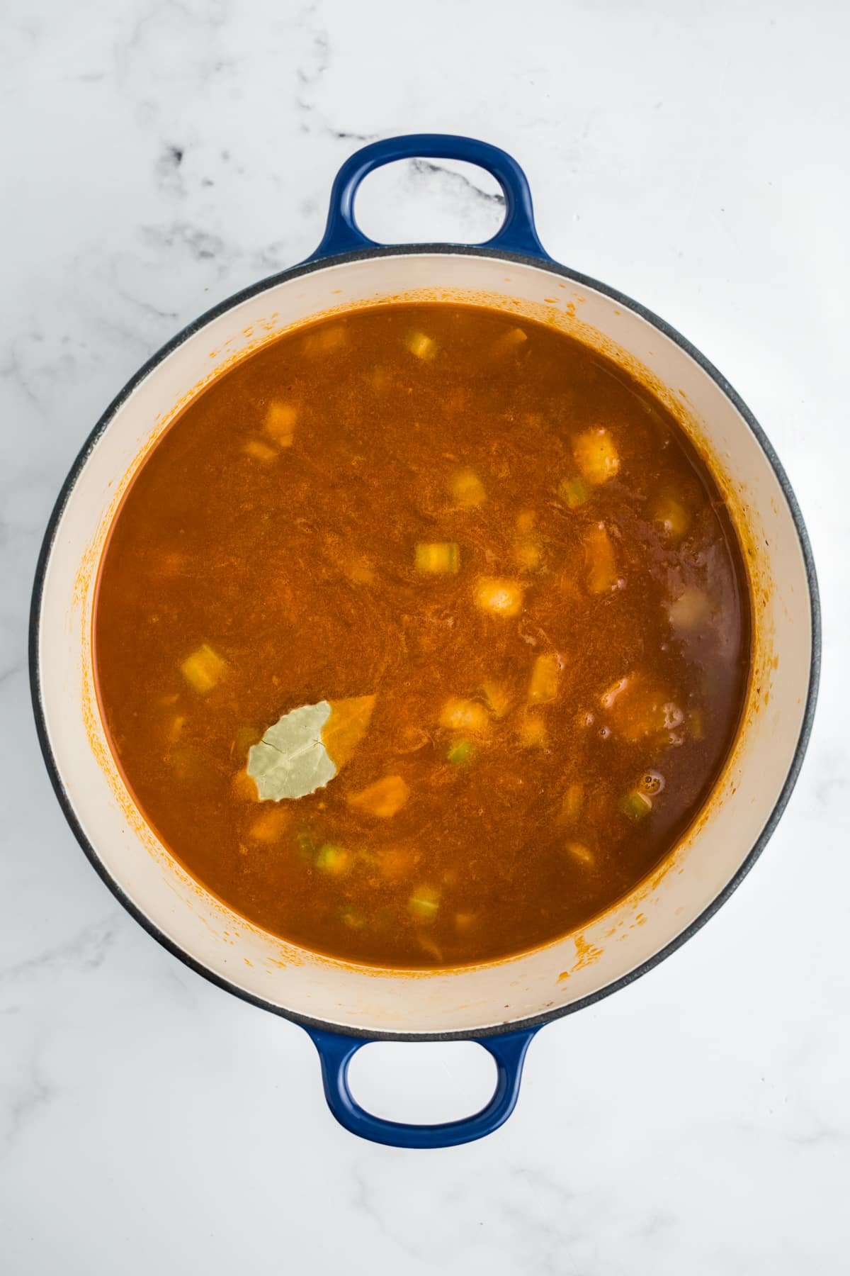 Beef broth, potatoes, bay leaf and Worcestershire sauce added to the pot.