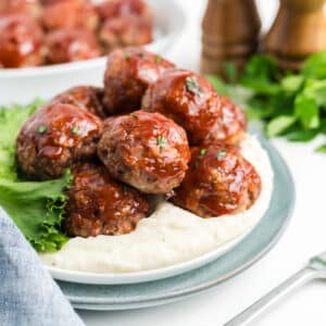 Meatloaf meatballs on a plate over potatoes.