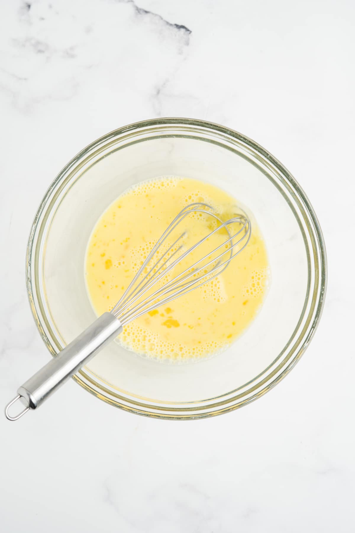Eggs and milk combined in a mixing bowl.