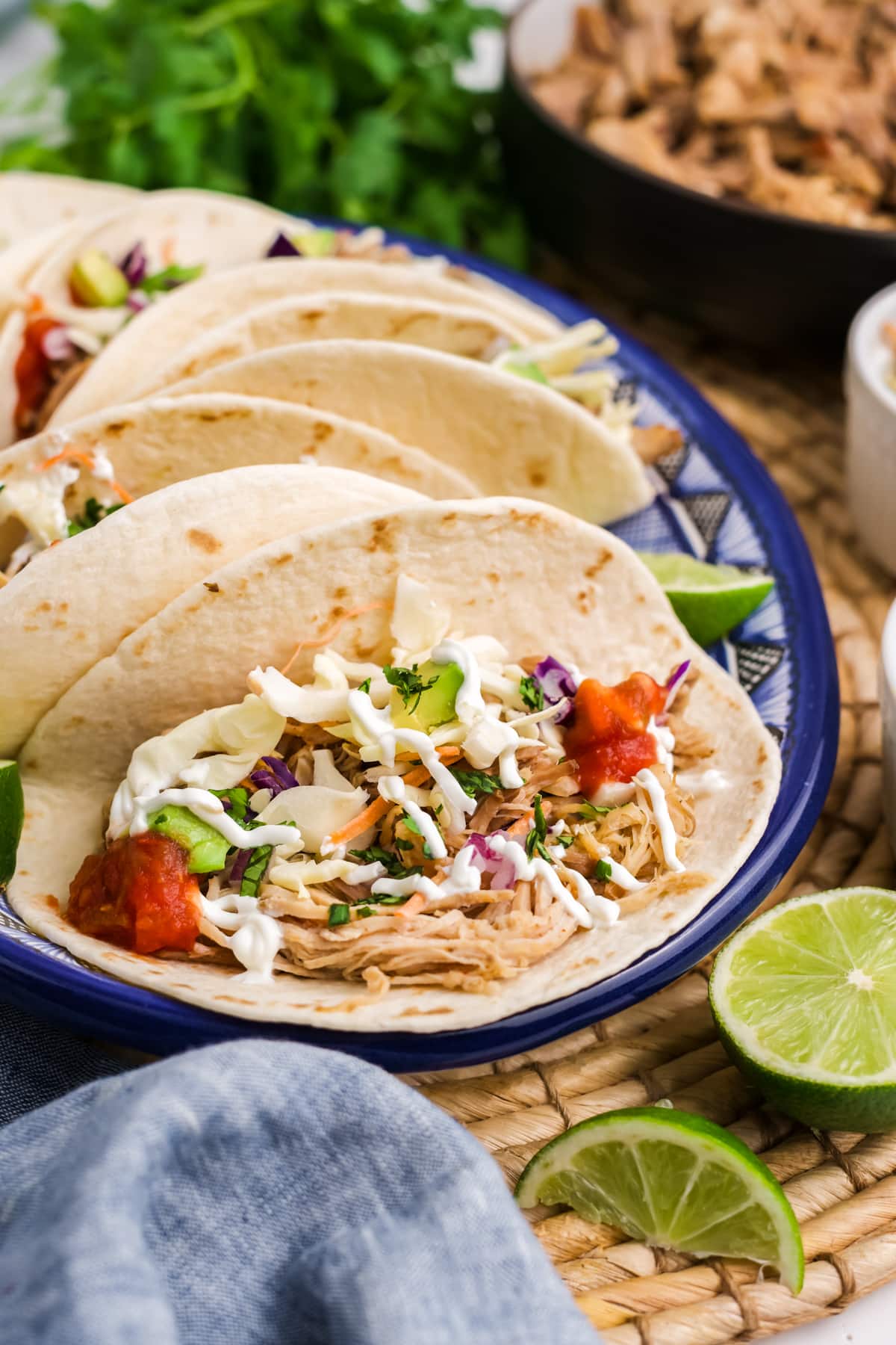A pulled pork taco on a plate, showing the toppings.