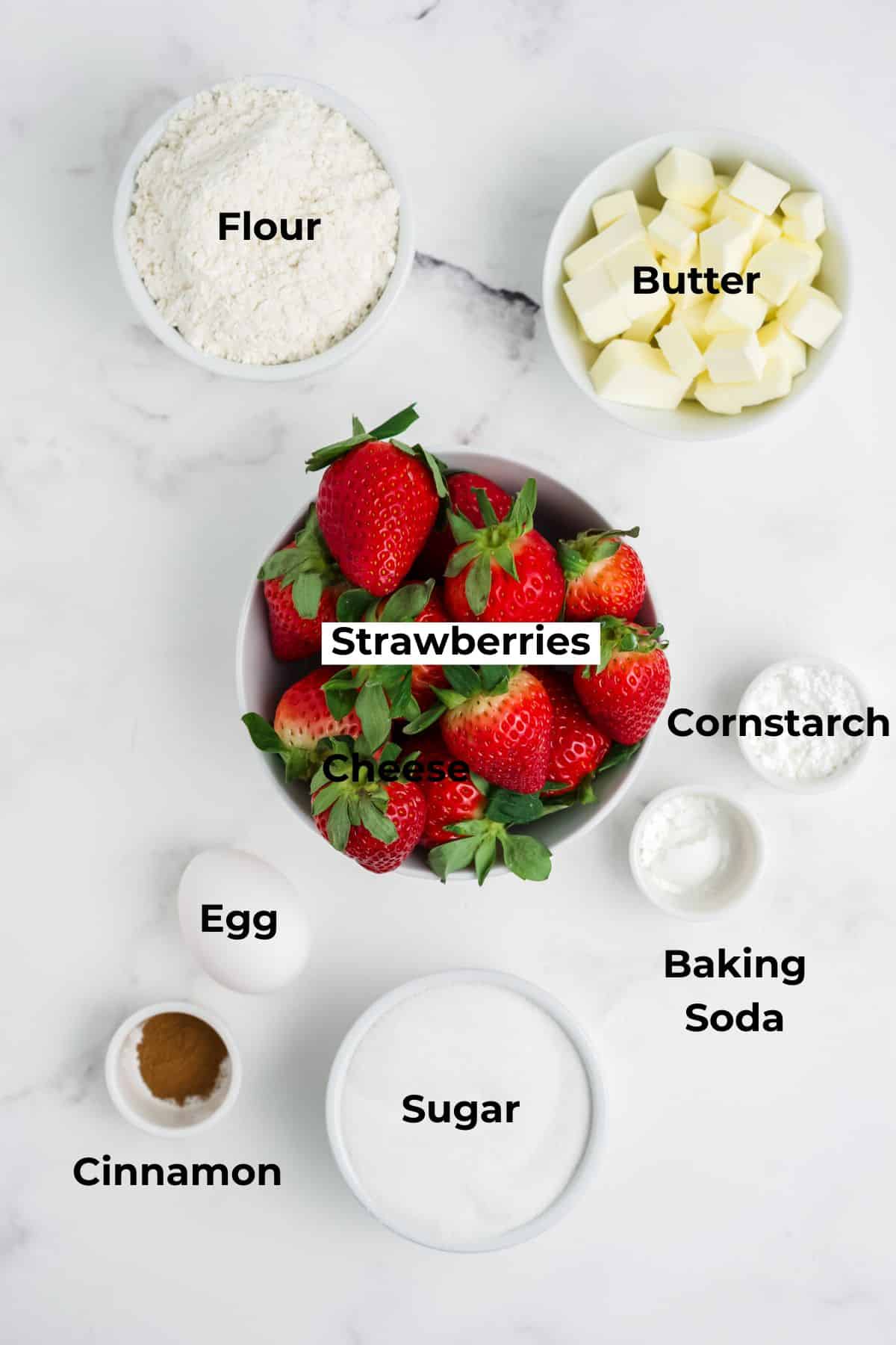Ingredients to make fresh strawberry bars in bowls on a table.
