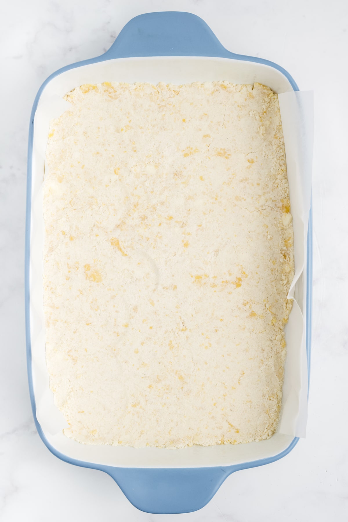 Some of the dough pressed at the bottom of the baking dish.