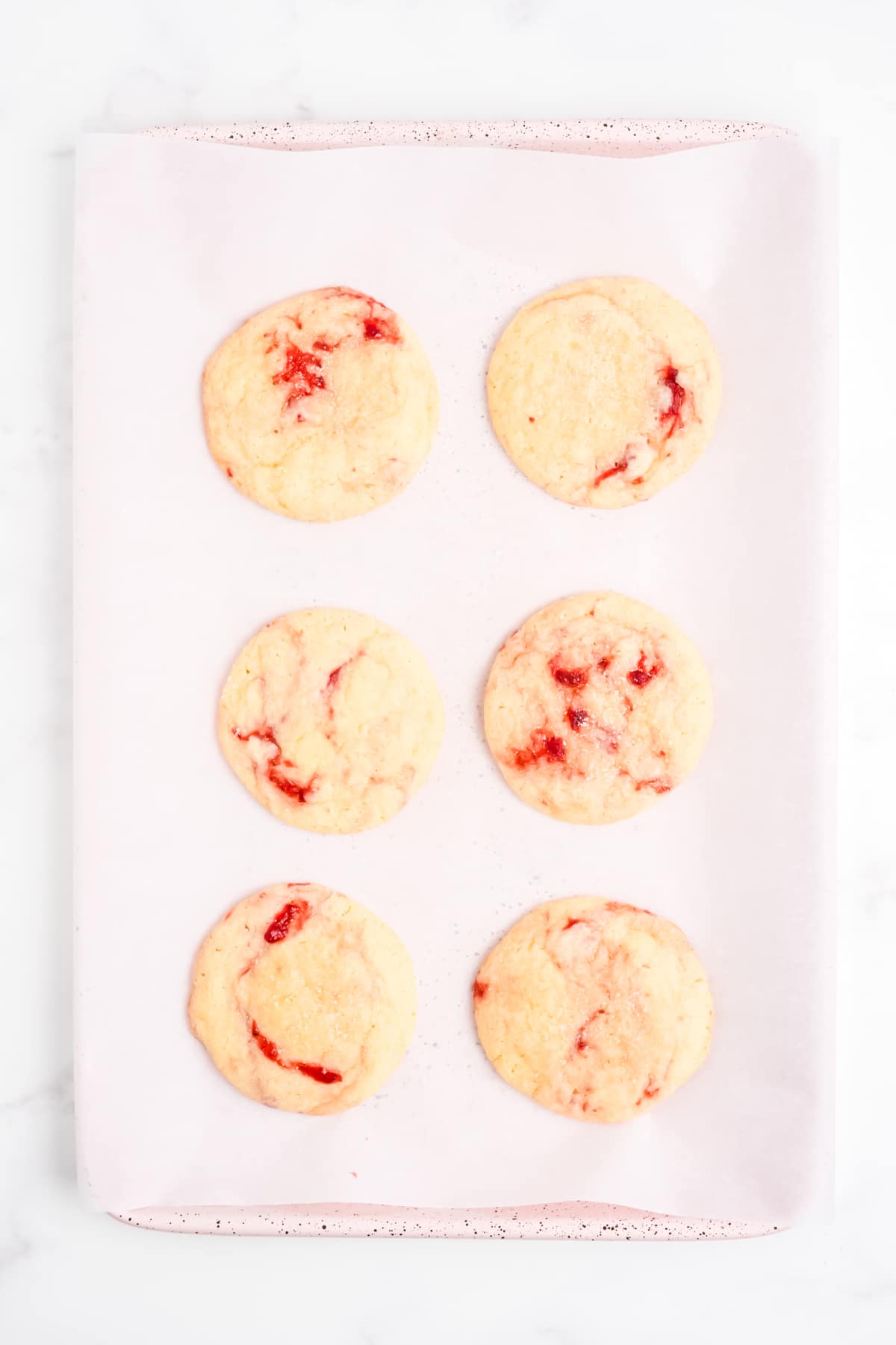 The cookies baked and cooling on a baking sheet.