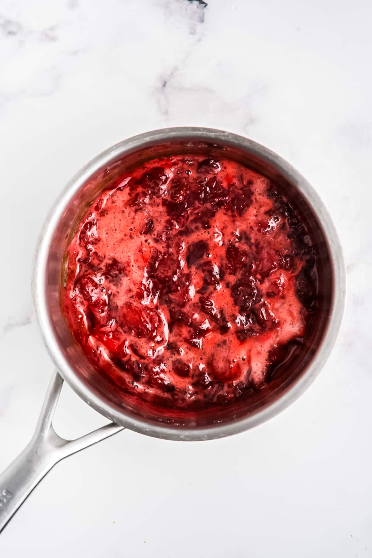 The strawberries and sugar cooking in the pot.