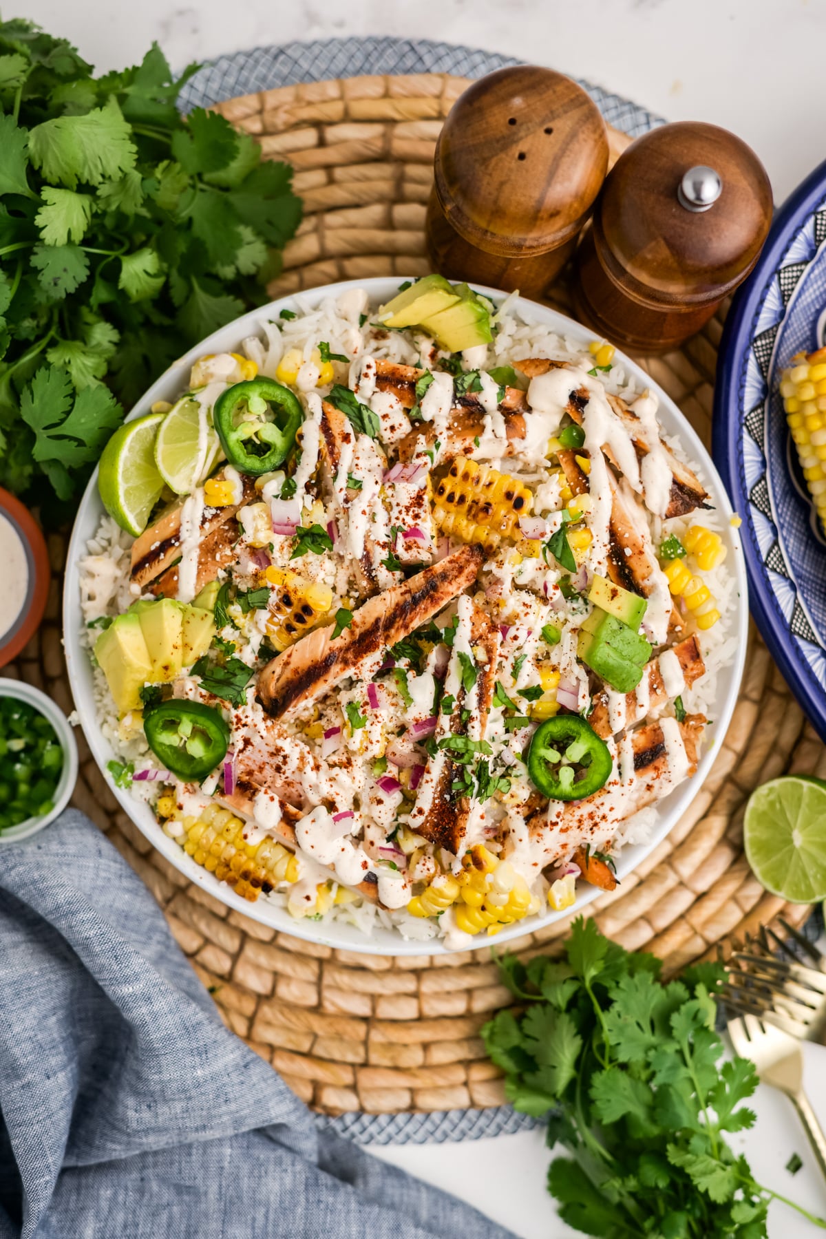 Overhead image of street corn chicken and rice bowls with elote dressing.